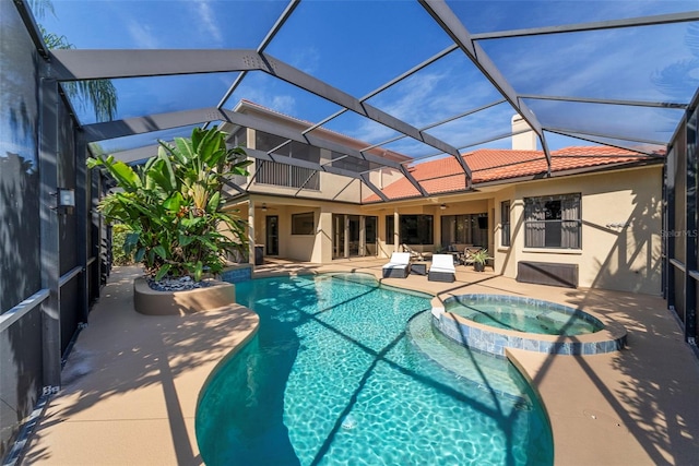 view of swimming pool with glass enclosure, an in ground hot tub, ceiling fan, and a patio