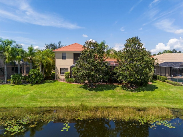 rear view of house featuring a lawn and a water view