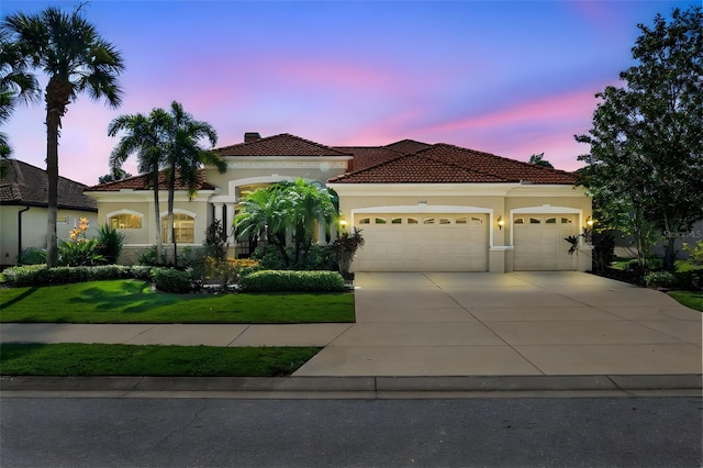 mediterranean / spanish house featuring a yard and a garage