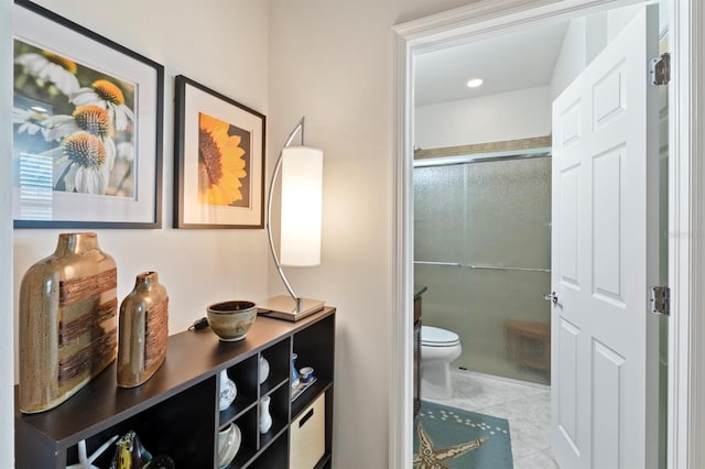 bathroom featuring a shower with door, toilet, and tile patterned flooring