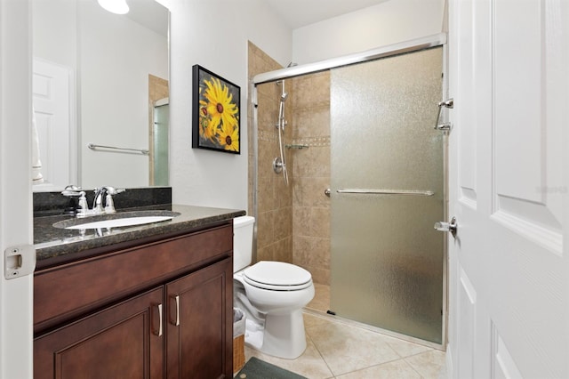 bathroom with tile patterned flooring, vanity, toilet, and walk in shower