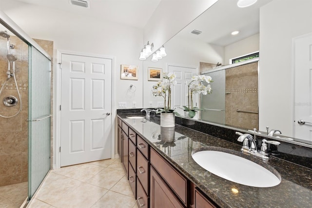 bathroom with tile patterned floors, a shower with shower door, and vanity