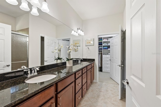 bathroom featuring tile patterned flooring, vanity, and a shower with shower door