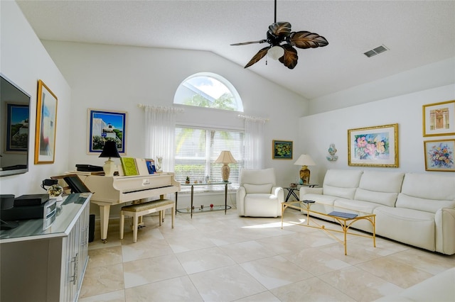 living room with a textured ceiling, high vaulted ceiling, light tile patterned flooring, and ceiling fan