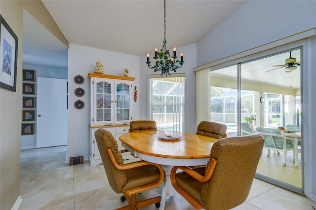 dining area featuring a textured ceiling and ceiling fan with notable chandelier