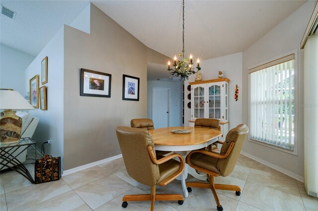 dining room with vaulted ceiling and an inviting chandelier