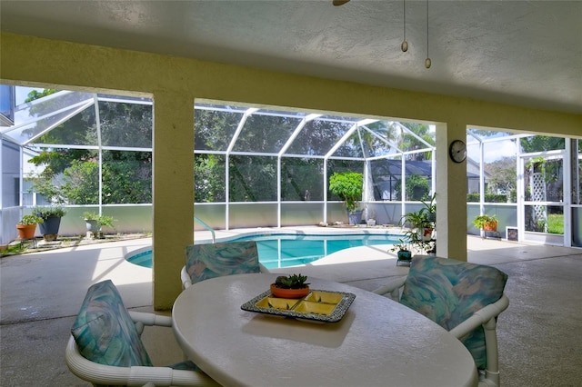 view of pool with glass enclosure and a patio area