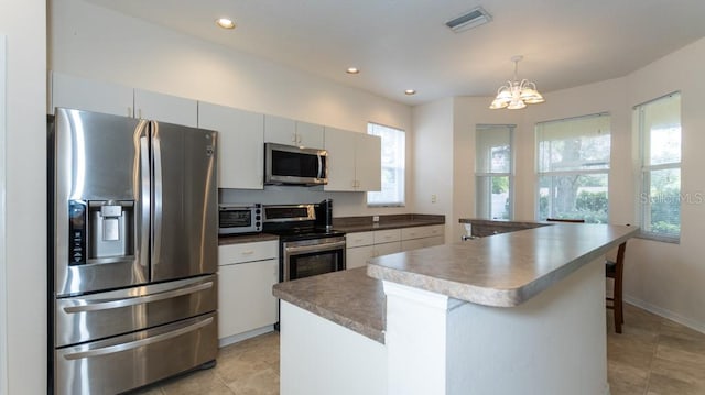 kitchen with a center island, decorative light fixtures, stainless steel appliances, a notable chandelier, and a breakfast bar area