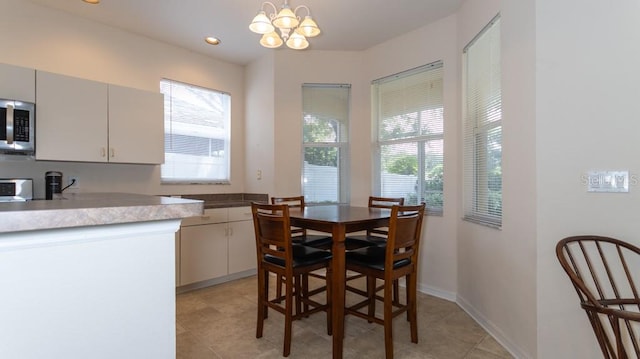 dining area featuring light tile patterned floors and a notable chandelier