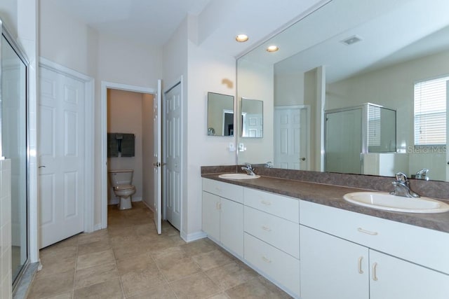 bathroom with vanity, toilet, and an enclosed shower