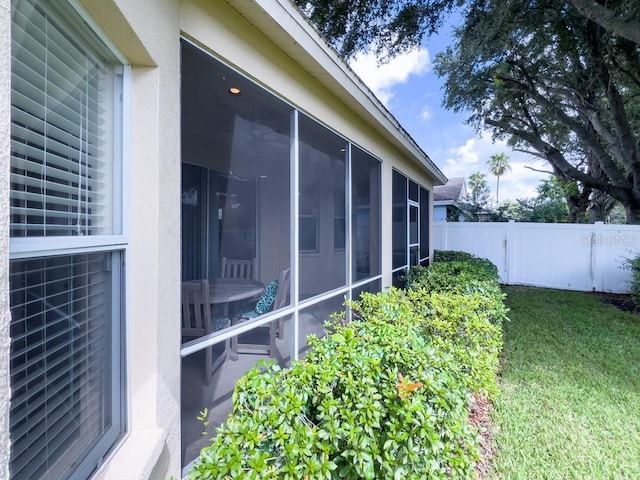 view of property exterior with a lawn and a sunroom