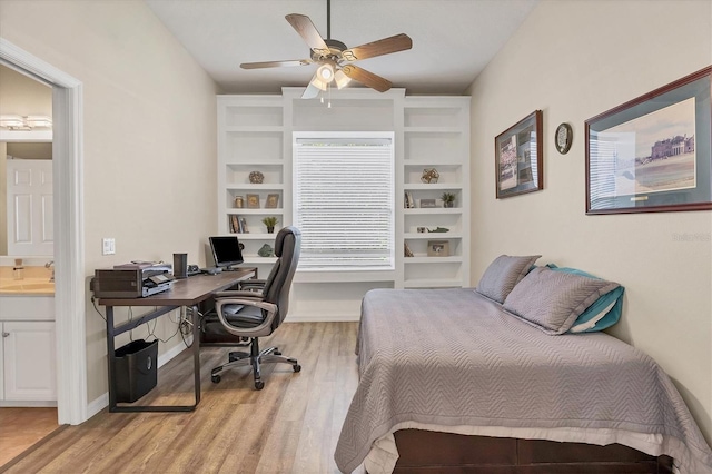 bedroom featuring light wood-type flooring, ceiling fan, connected bathroom, and sink