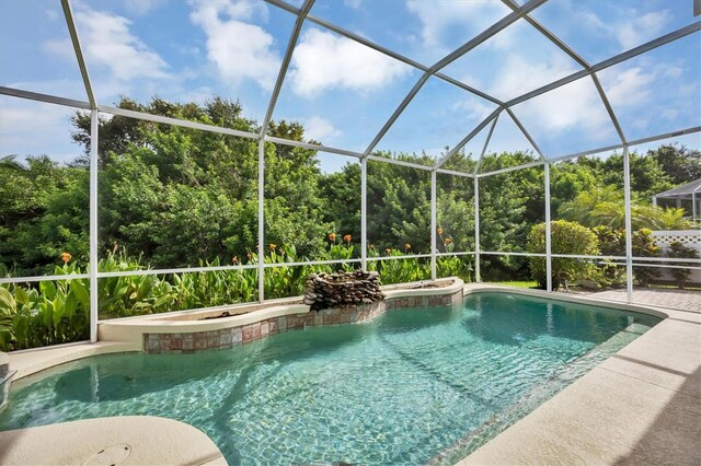 view of pool with a lanai and a hot tub