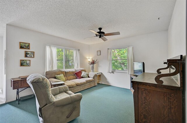 living room featuring ceiling fan, carpet floors, and a textured ceiling