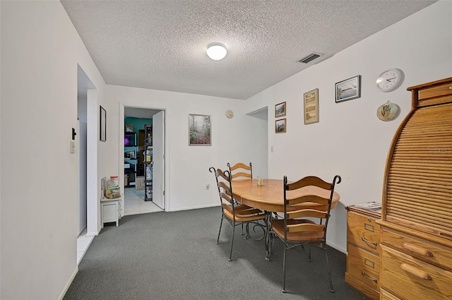 carpeted dining space with a textured ceiling