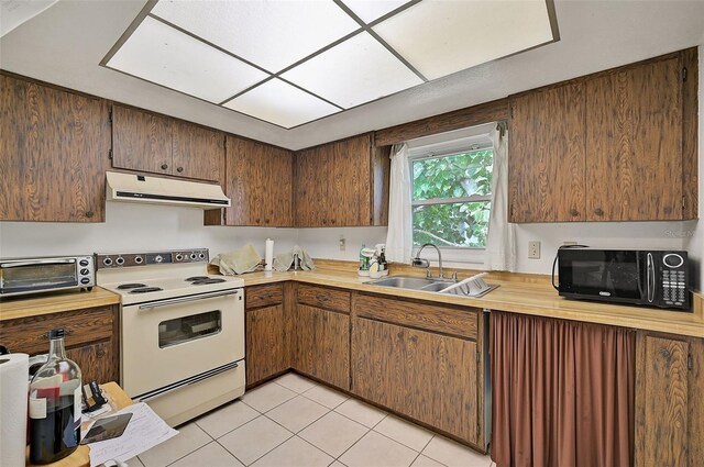 kitchen featuring sink, light tile patterned floors, and white electric range