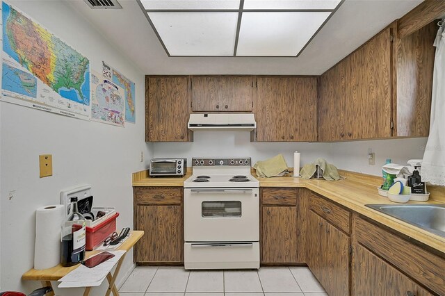 kitchen featuring light tile patterned floors and white range with electric stovetop