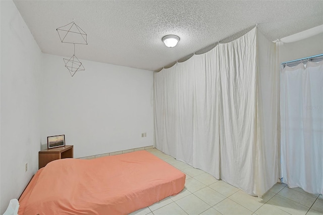 tiled bedroom with a textured ceiling