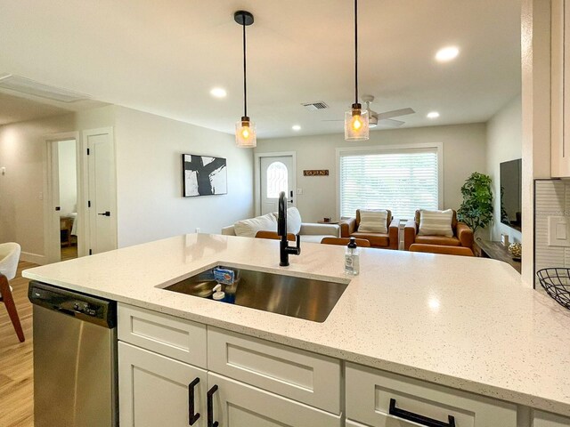 kitchen featuring light wood-type flooring, dishwasher, sink, ceiling fan, and hanging light fixtures