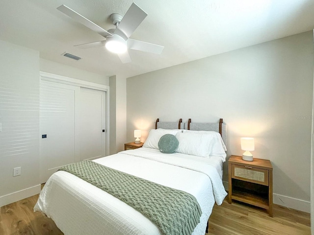 bedroom with wood-type flooring, ceiling fan, and a closet