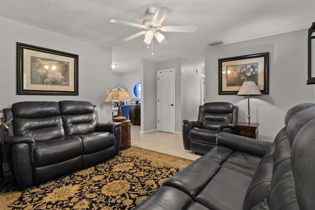 tiled living room with a textured ceiling and ceiling fan