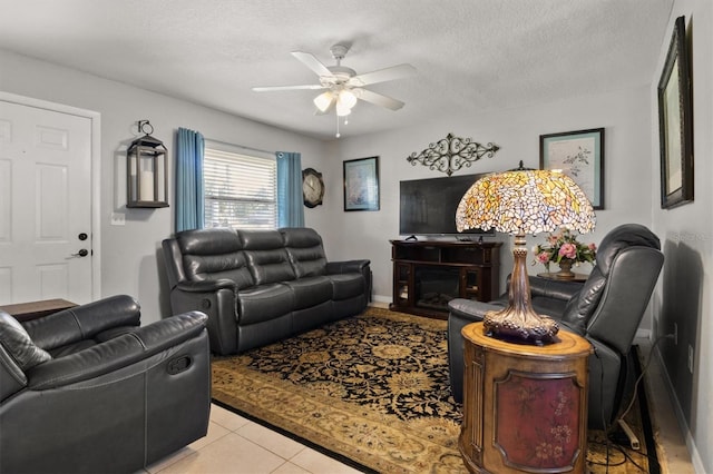 living room with ceiling fan, light tile patterned floors, and a textured ceiling