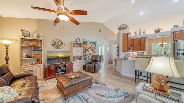 tiled living room with high vaulted ceiling, ceiling fan with notable chandelier, and sink