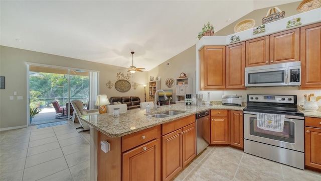 kitchen with stainless steel appliances, sink, vaulted ceiling, and kitchen peninsula