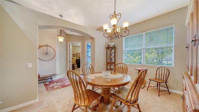 carpeted dining area with an inviting chandelier