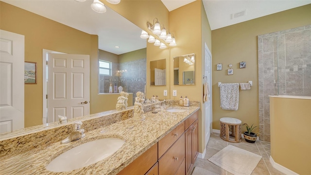 bathroom featuring vanity, tiled shower, and tile patterned floors