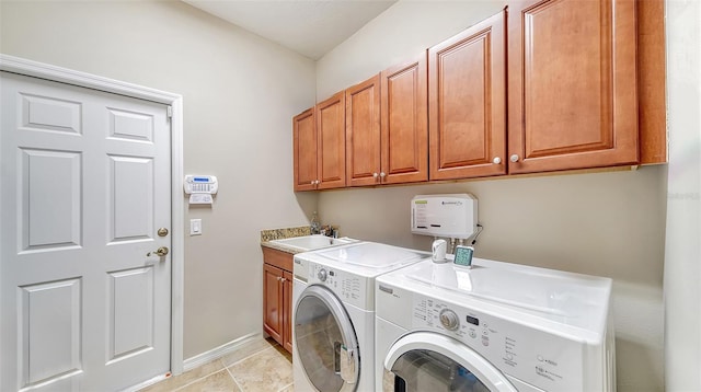 laundry room with light tile patterned floors, washer and dryer, cabinets, and sink