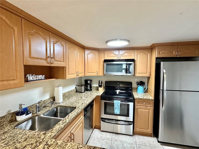 kitchen featuring light stone counters, light tile patterned floors, stainless steel appliances, and sink