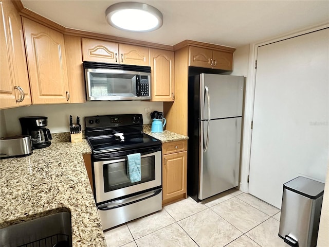 kitchen with appliances with stainless steel finishes, light tile patterned flooring, light brown cabinets, and light stone counters