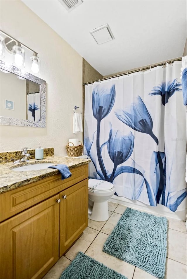 bathroom with vanity, toilet, and tile patterned floors