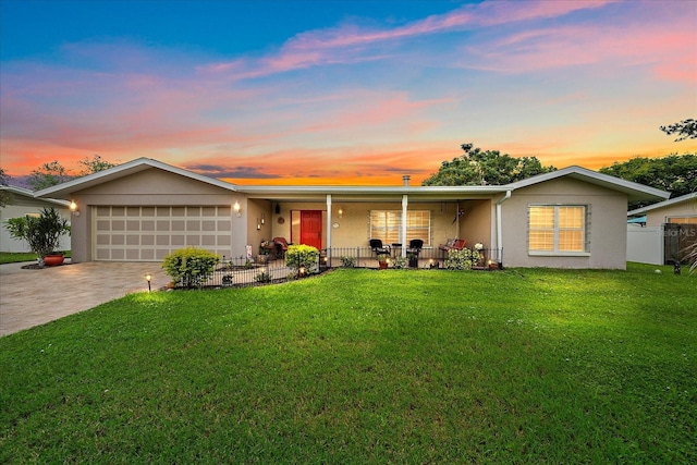 single story home featuring a lawn and a garage