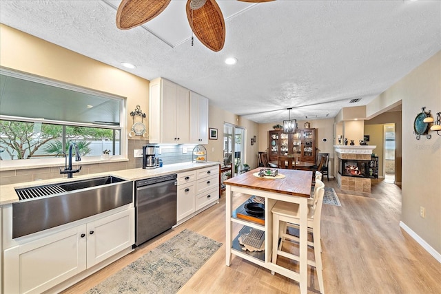 kitchen featuring a wealth of natural light, dishwasher, and white cabinetry