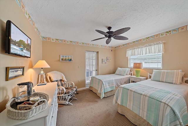 bedroom with ceiling fan, carpet floors, and a textured ceiling