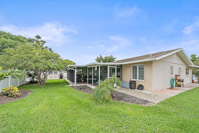 rear view of property featuring a sunroom and a lawn