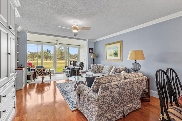 living room with a textured ceiling, light hardwood / wood-style flooring, ceiling fan, and crown molding