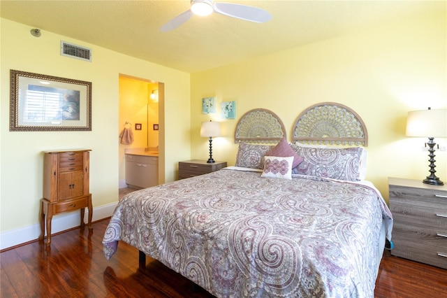 bedroom with a textured ceiling, ensuite bath, ceiling fan, and dark hardwood / wood-style flooring