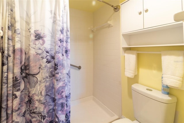 bathroom with toilet and a shower with shower curtain