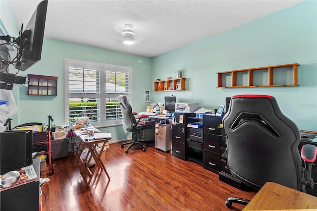 home office with a textured ceiling and dark wood-type flooring