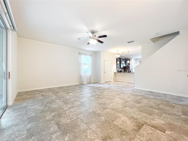 unfurnished living room with baseboards, ceiling fan, and visible vents