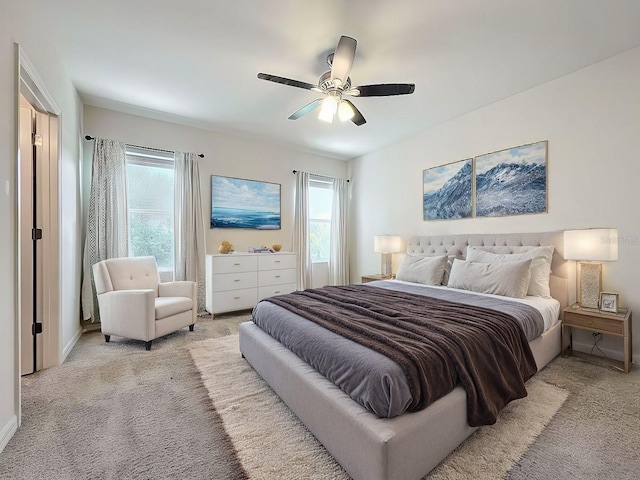 carpeted bedroom featuring multiple windows and ceiling fan