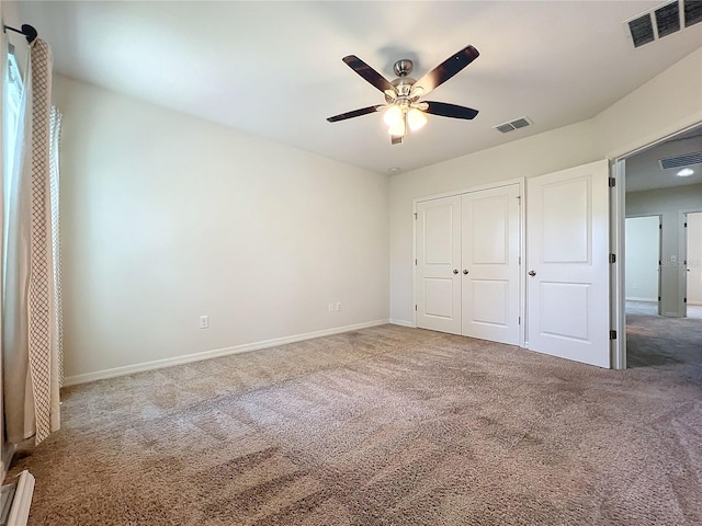 unfurnished bedroom with a baseboard heating unit, a closet, ceiling fan, and carpet floors