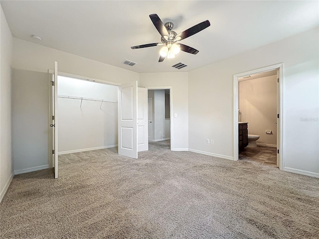 unfurnished bedroom with carpet flooring, ceiling fan, ensuite bathroom, and a closet