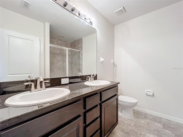 bathroom with toilet, a sink, a stall shower, and visible vents