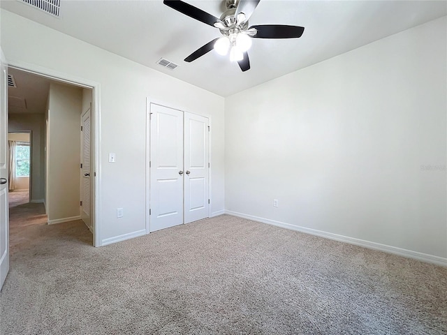 unfurnished bedroom featuring ceiling fan, a closet, and carpet