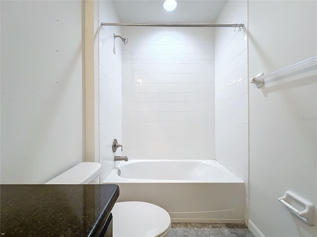 bathroom featuring tiled shower / bath combo and toilet