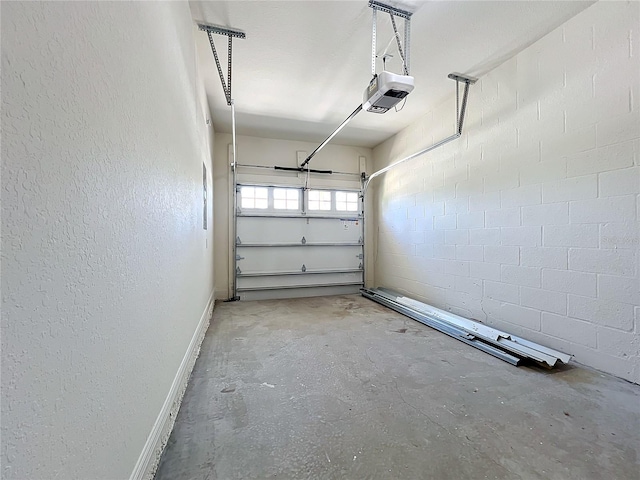 garage with a garage door opener and a textured wall